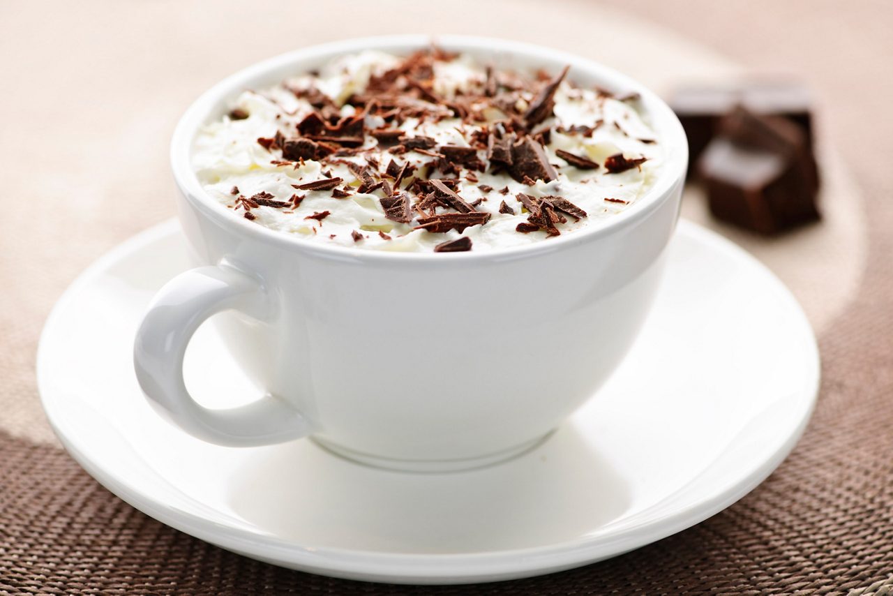 Cup of hot cocoa with shaved chocolate and whipped cream