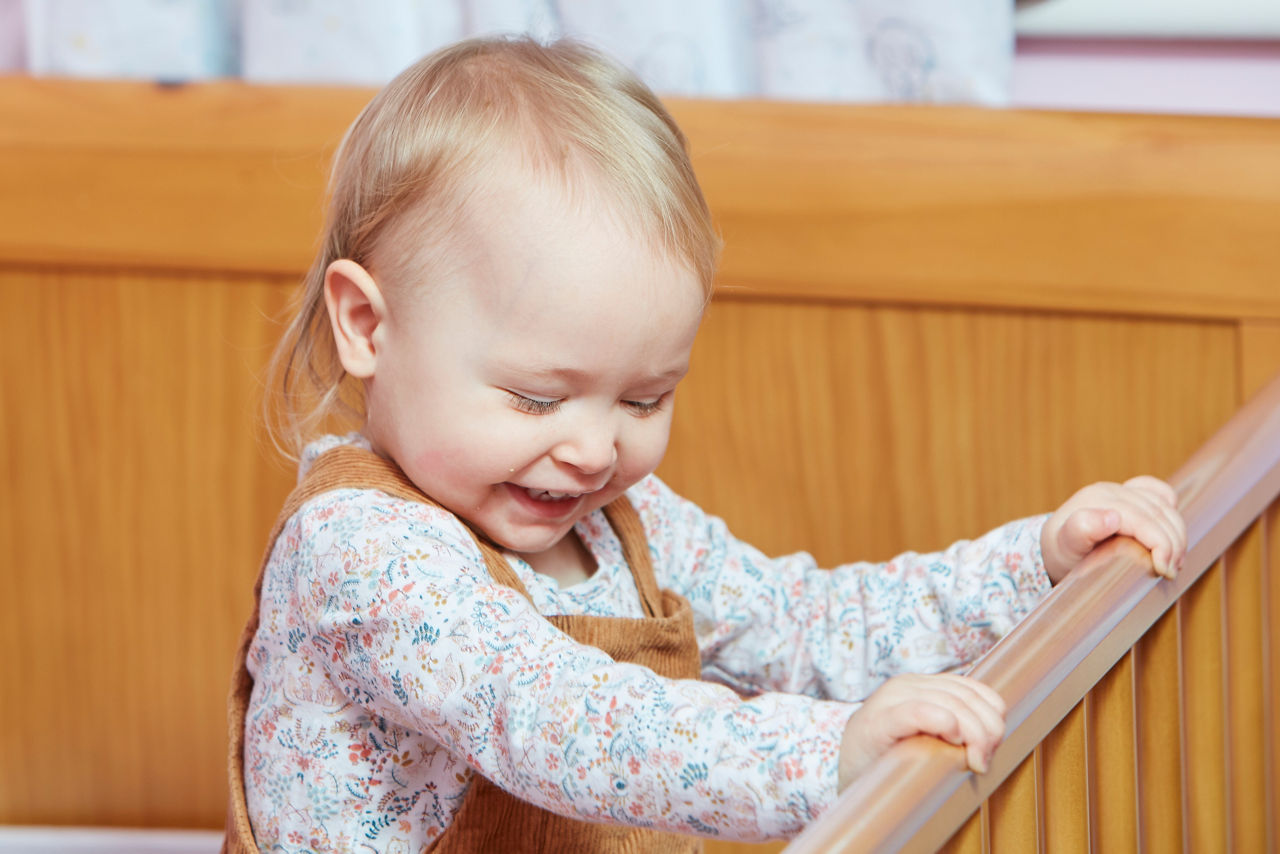 Baby laughing in a crib