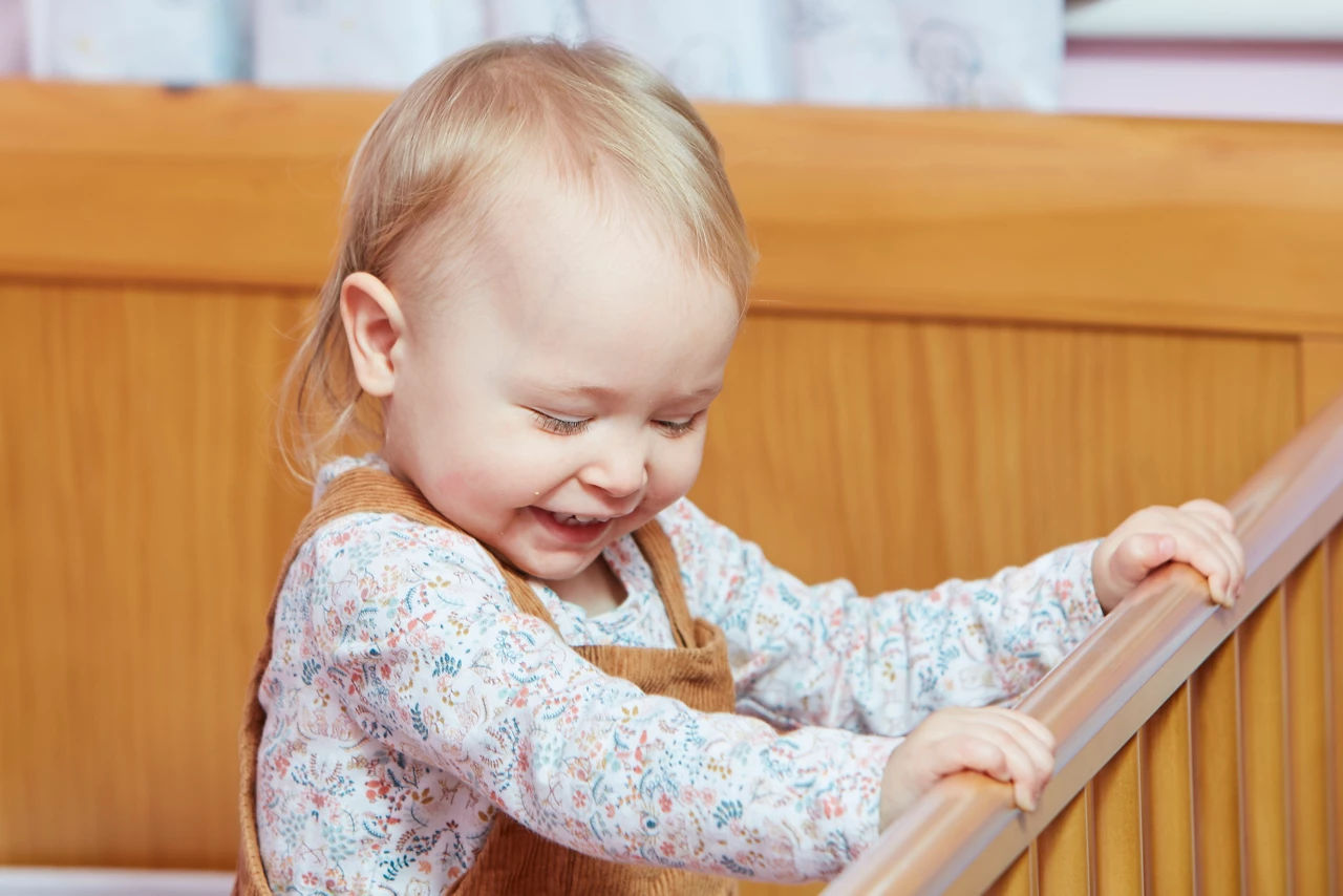 Toddler in a crib, smilling