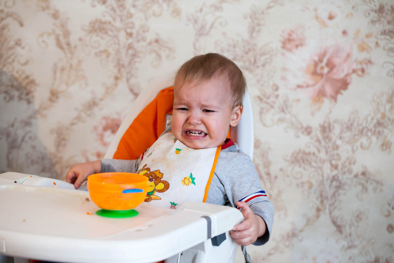 Little baby boy crying and screaming during eating, sitting in highchair; Shutterstock ID 571029838,unhappy baby crying in highchair