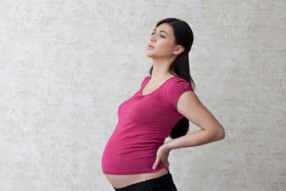 Pregnant woman holding her back