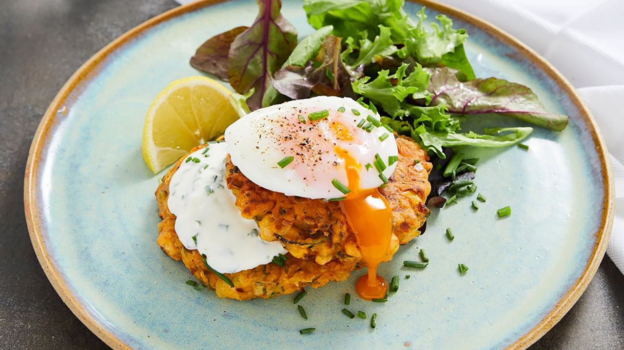 Un plato con dos huevos fritos y una ensalada colorida, ideal para una dieta saludable durante el embarazo