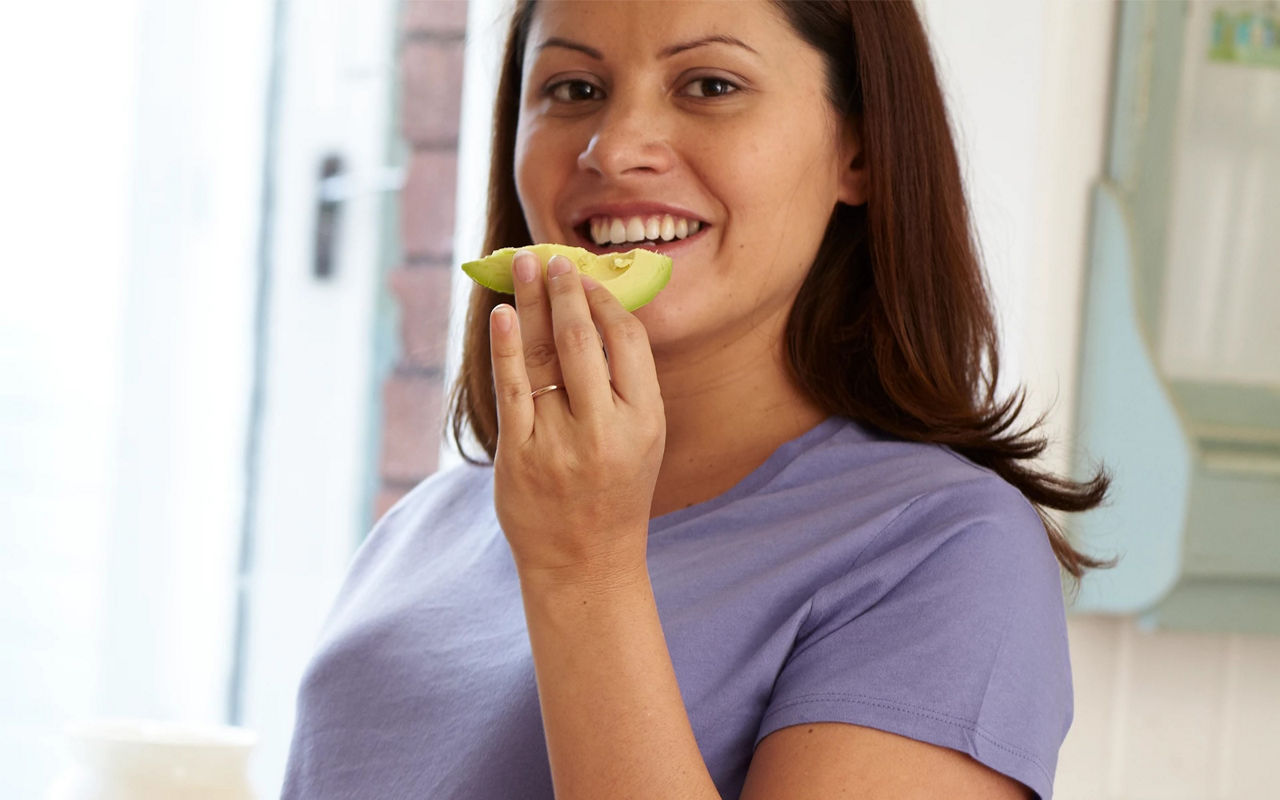 Woman eating avocado