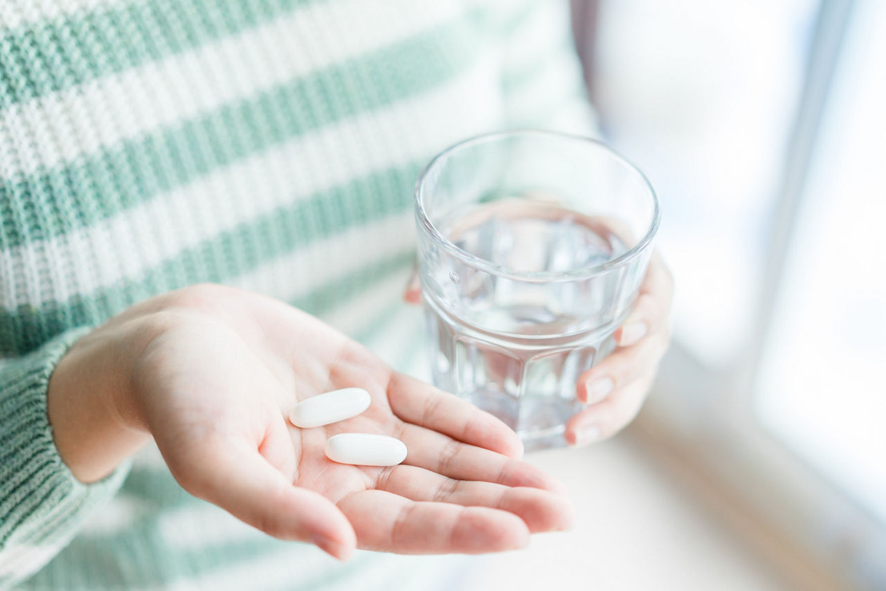 woman-holding-vitamins-water