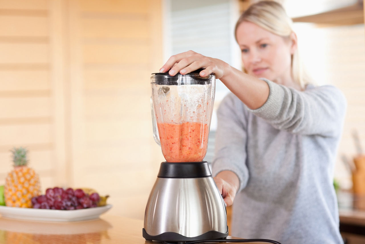 Side view of modern blender chopping fruits