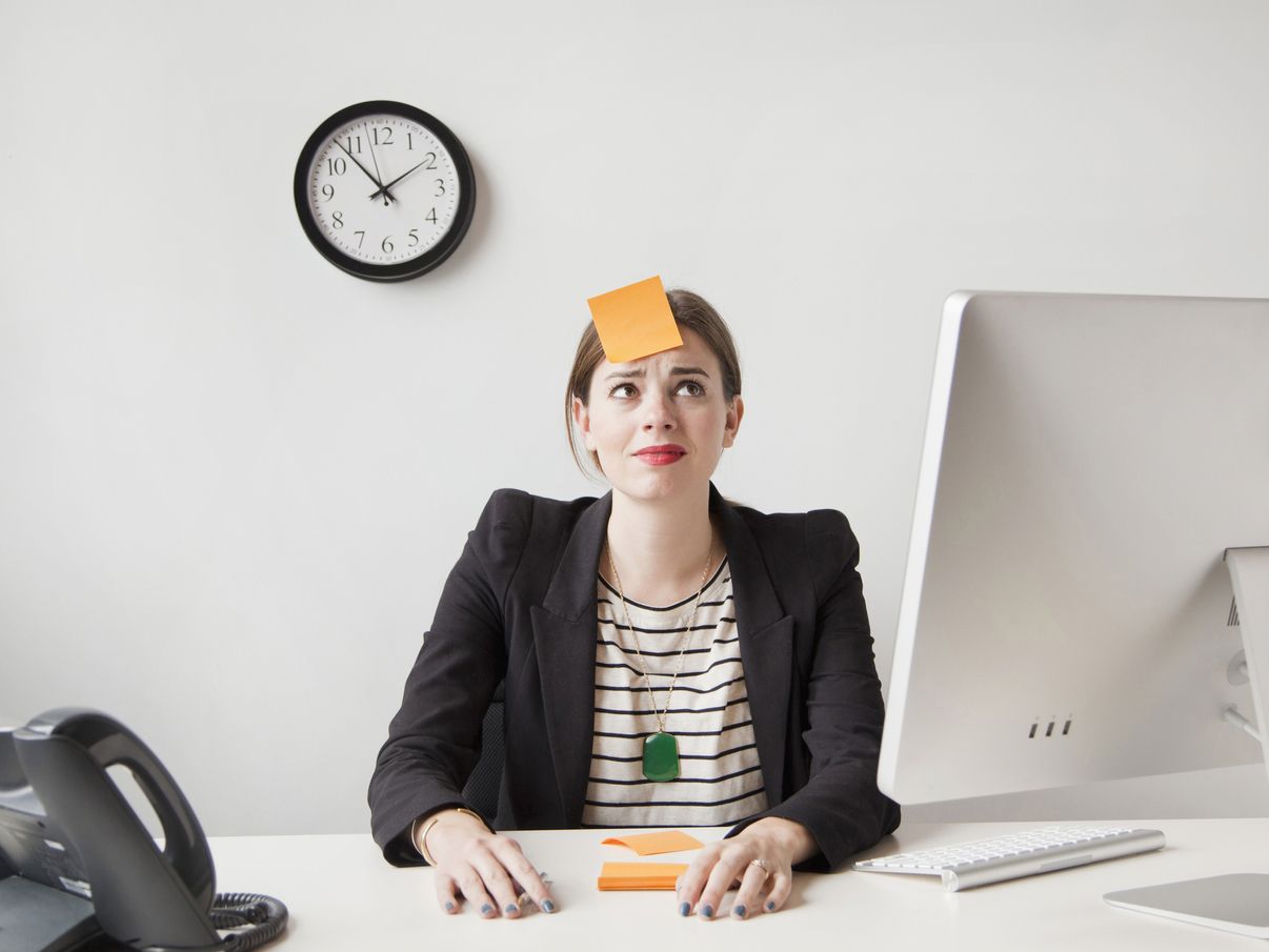 Studio shot of young woman working in office with adhesive note on her forehead; Shutterstock ID 264020945,woman working with postit stuck to forehead