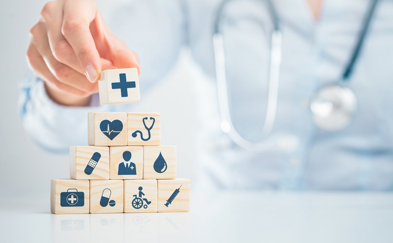 Hand arranging wood block with healthcare medical icon. Health insurance - concept.getty images 1189132246